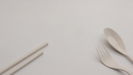 White plastic spoon, fork and chopsticks isolated on white background