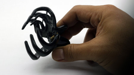 Hand holding hair clip isolated on white backgroundの写真素材