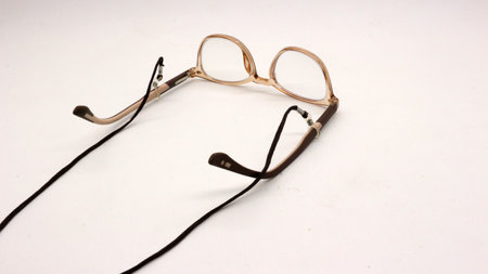 Glasses with black eyeglass strap on white background.