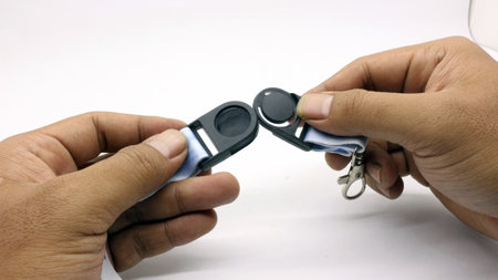 The neck lanyard is held by an adult's hand on a white background