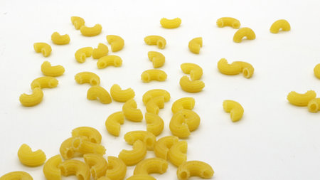 Macaroni pasta uncooked isolated on white backgroundの写真素材