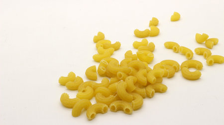 Macaroni pasta uncooked isolated on white backgroundの写真素材