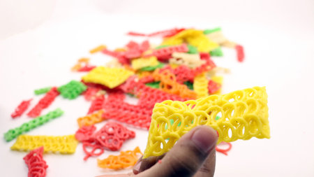 Hand holding colorful crackers or krupuk unfired isolated on white backgroundの写真素材