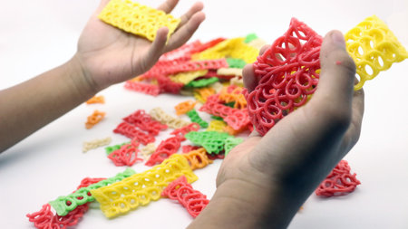 Hand holding colorful crackers or krupuk unfired isolated on white backgroundの写真素材