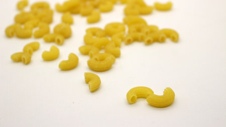 Macaroni pasta uncooked isolated on white backgroundの写真素材