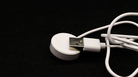 USB charger cable for smart watch isolated on black background