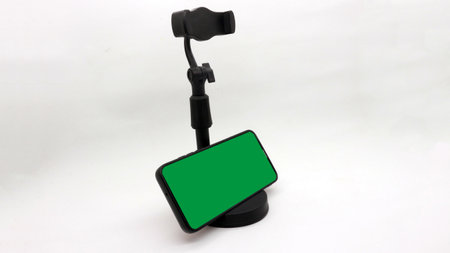 Black stand holder for smart phone with green screen isolated on white backgroundの写真素材