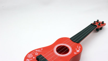 Red ukulele toy for kids isolated on white background