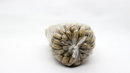 Peanuts in a plastic bag on a white background