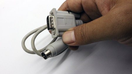 Hand holding RS-232 VGA cable isolated on white background