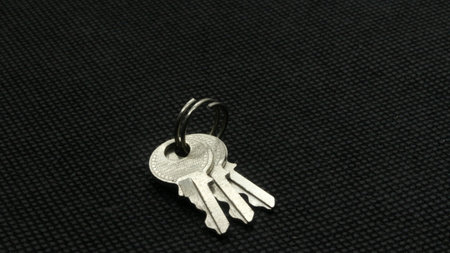 Small silver metal key isolated on black background