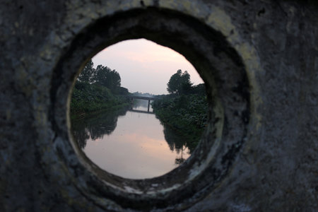 Old stone bridge of river with hole in the sideの写真素材
