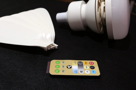 Ceiling fan with LED light and remote control isolated on black background