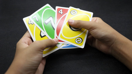 Hands playing cards on a black background