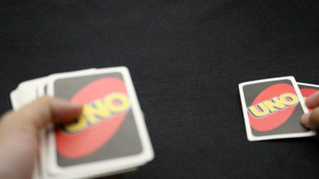 Hands playing cards on a black background