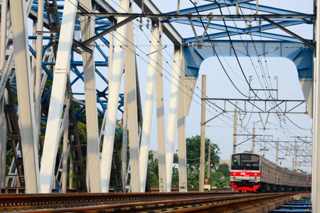 The train crosses the blue steel bridge in the urban area