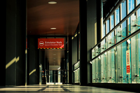 Escalator signs inside a train station with light and shadow