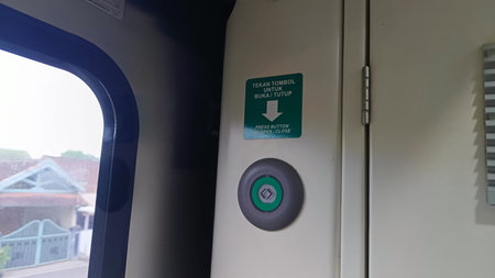 Close up image of train door opener button near window