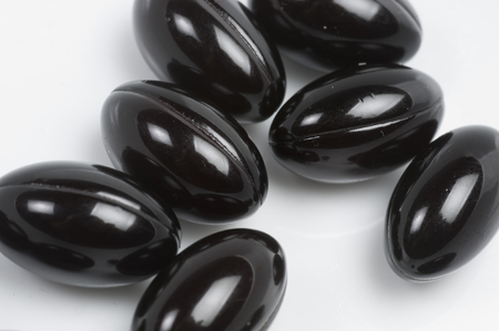 Black vitamin supplements looks like cloned black bugs when photographed close up.  These gel tablets are touted with improving the health of many, and most don't require a prescription.の写真素材