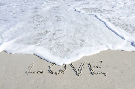 The surf of the ocean threatens to wipe away the wordの写真素材