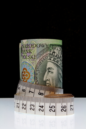 Budget - 100 Polish Zloty banknotes with tape measure on black backgroundの写真素材