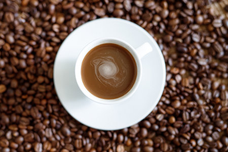 Coffee cup on coffee beans background. Top view with copy space.の写真素材