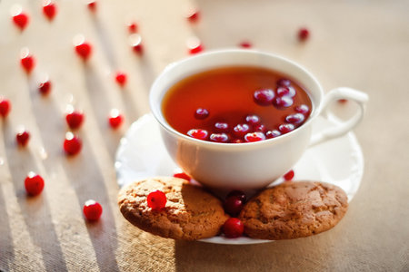 Cup of tea with cookies and pomegranate on wooden tableの写真素材