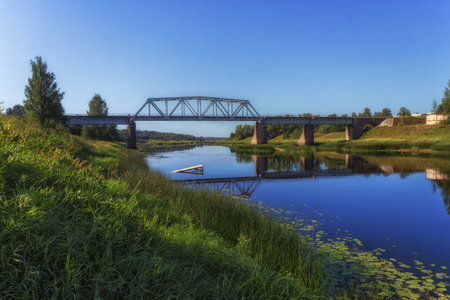 Old railway bridge over the river in the village of Vologdaの写真素材