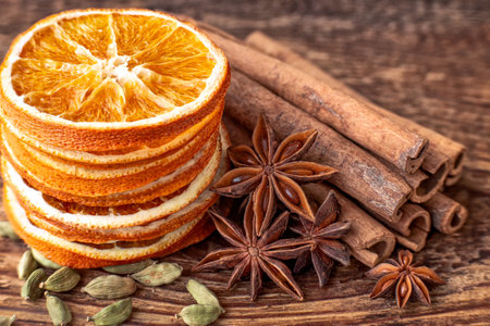 Cinnamon sticks, star anise and dried orange slices on wooden backgroundの写真素材
