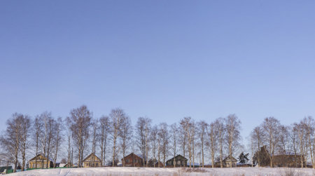 Wooden houses on the background of a blue sky in winter.の写真素材