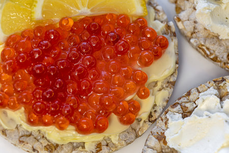 Crispbread with red caviar and lemon on a white backgroundの写真素材