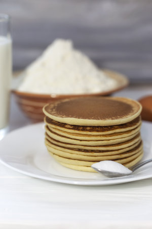 Pancakes with milk and eggs on a white plate. Selective focus.