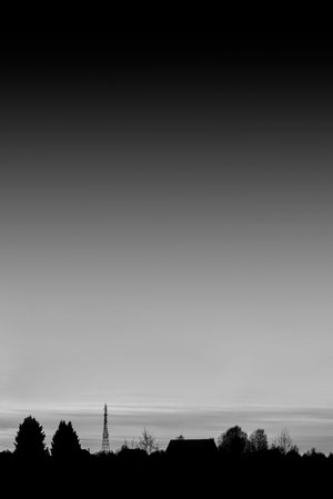 Silhouette of a house and trees against a dark sky.の写真素材