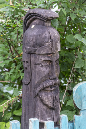 Old wooden carved totem pole in the garden, closeup of photoの写真素材