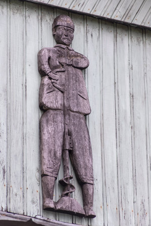 Sculpture of a soldier on the wall of a wooden houseの写真素材