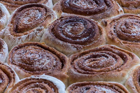 Freshly baked cinnamon buns with sugar powder. selective focus.の写真素材