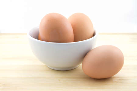 chicken eggs in bowl on bamboo table
