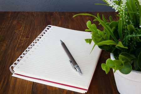 blank notebook with pencil on wooden table