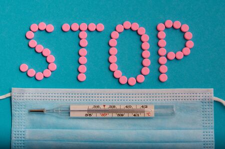 Medical mask, mercury thermometer and pink antibiotic pillsの写真素材