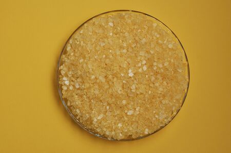 Yellow bath salt crystals in a glass plate for spa or self-service