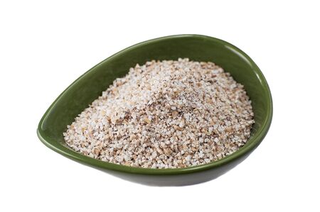Wheat groats in a green bowl Isolated on white backgroundの写真素材