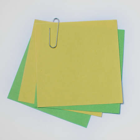 Paper stickers for recording tasks. The sheets are connected with a metal paper clipの写真素材