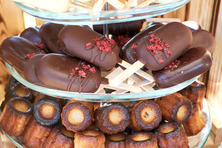 Cake pops in dark chocolate in the shape of a mini ice cream on a stick. cannelle on the bottom tier