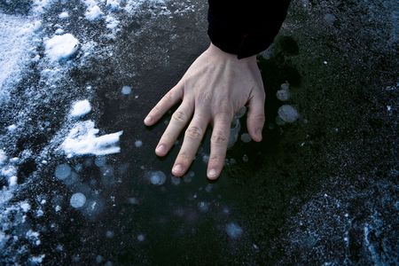 Frozen hand on cold iceの写真素材