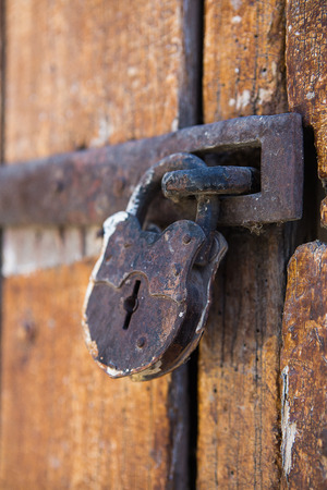 Rusty padlock on wooden doorの写真素材