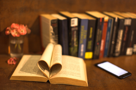 a book with pages heart silhouette and mobile phoneの写真素材