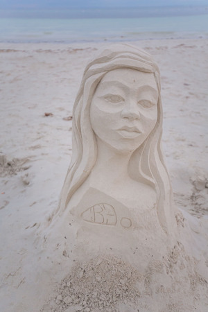 one has modeling an artistic woman doing bust sculpture on sand at a white beach a summer vacation sceneの写真素材