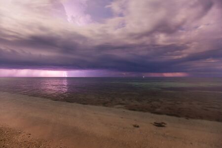 Dramatic clouds scape in a thunderstorm with lights in the dark night sky photography with long...