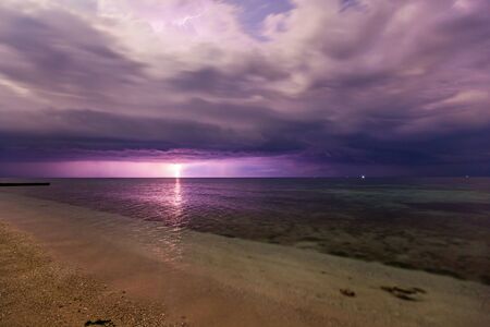 Dramatic clouds scape in a thunderstorm with lights in the dark night sky photography with long...