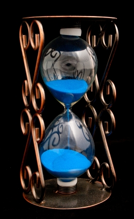 Hourglass with purple sand isolated on a black backgroundの写真素材